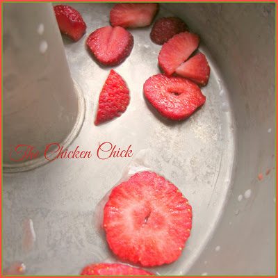 Place some sliced strawberries and/or strawberry hulls on the bottom of the frozen pan and place pan in freezer. (this ensures that the strawberries will be visible on the top of the ice ring after unmolding.)